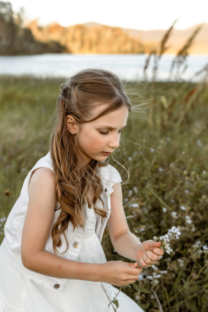 Young girl in family photoshoot picking flowers
