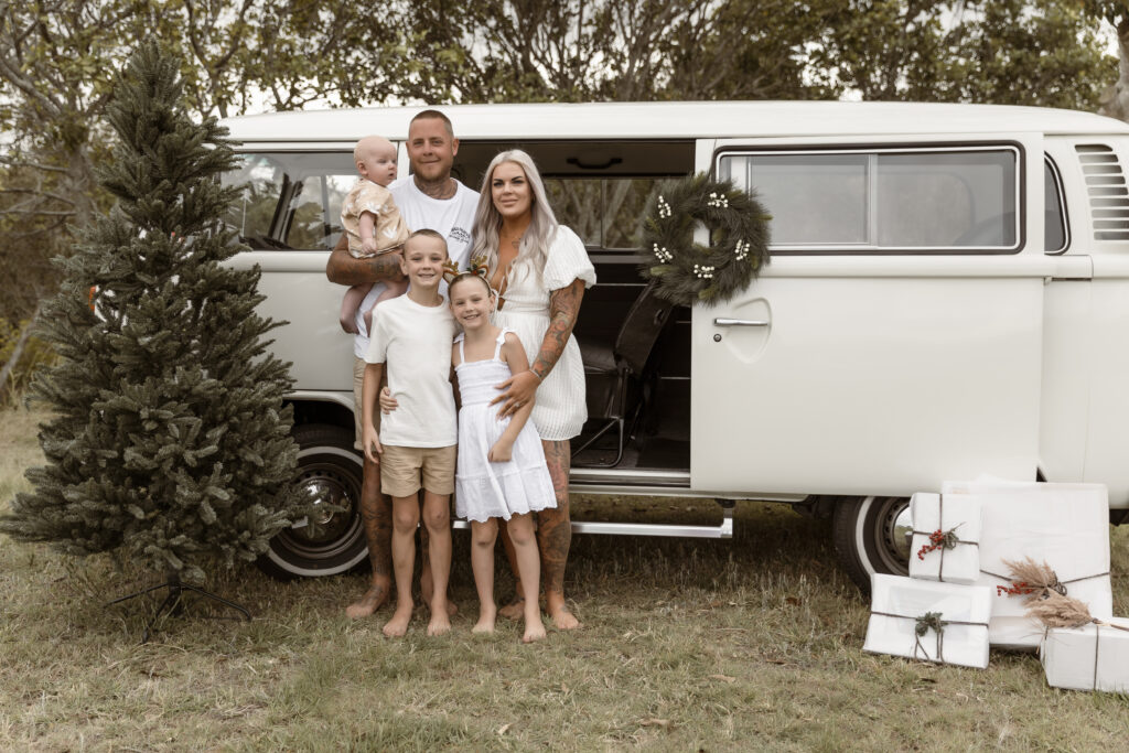 Outdoor Christmas Kombi Session including Mum, Dad and their three kids. All standing in front of a Christmas themed Kombi Van.