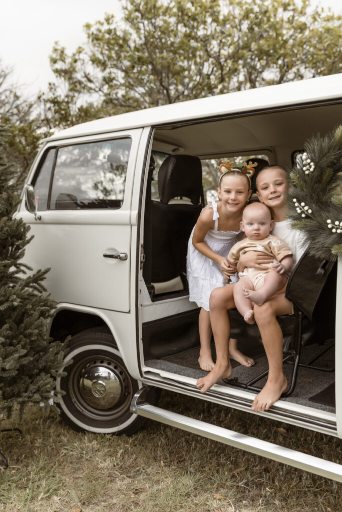 Outdoor Christmas Kombi Session showing an older brother, middle sister and baby.