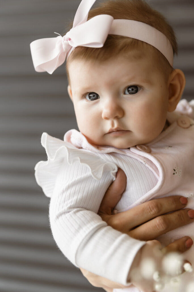 Cute baby with a pink bow looking at the camera