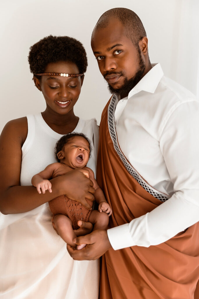 Mum and Dad holding their baby while wearing their cultural attire.