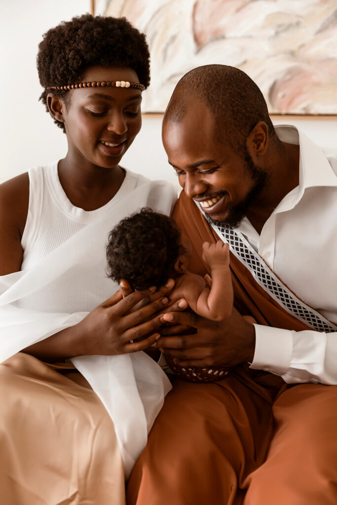 Mum and Dad looking at their baby while wearing their cultural attire.