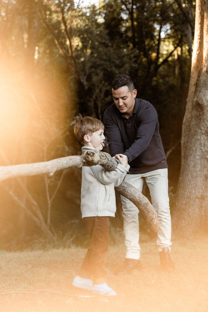 Winter glow around Dad and Son while they carry a heavy log together.